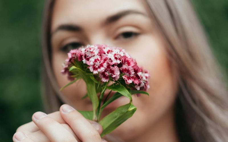 Mulher cheirando flores