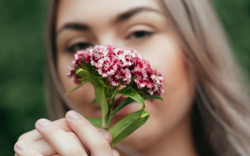 Garota loira cheirando flores