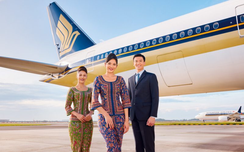 Tripulantes da Singapore Airlines em frente a um avião